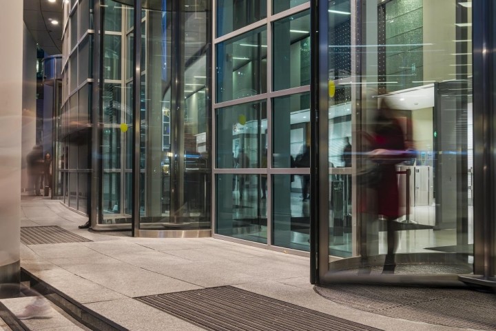 blurred image of people moving through revolving office door
